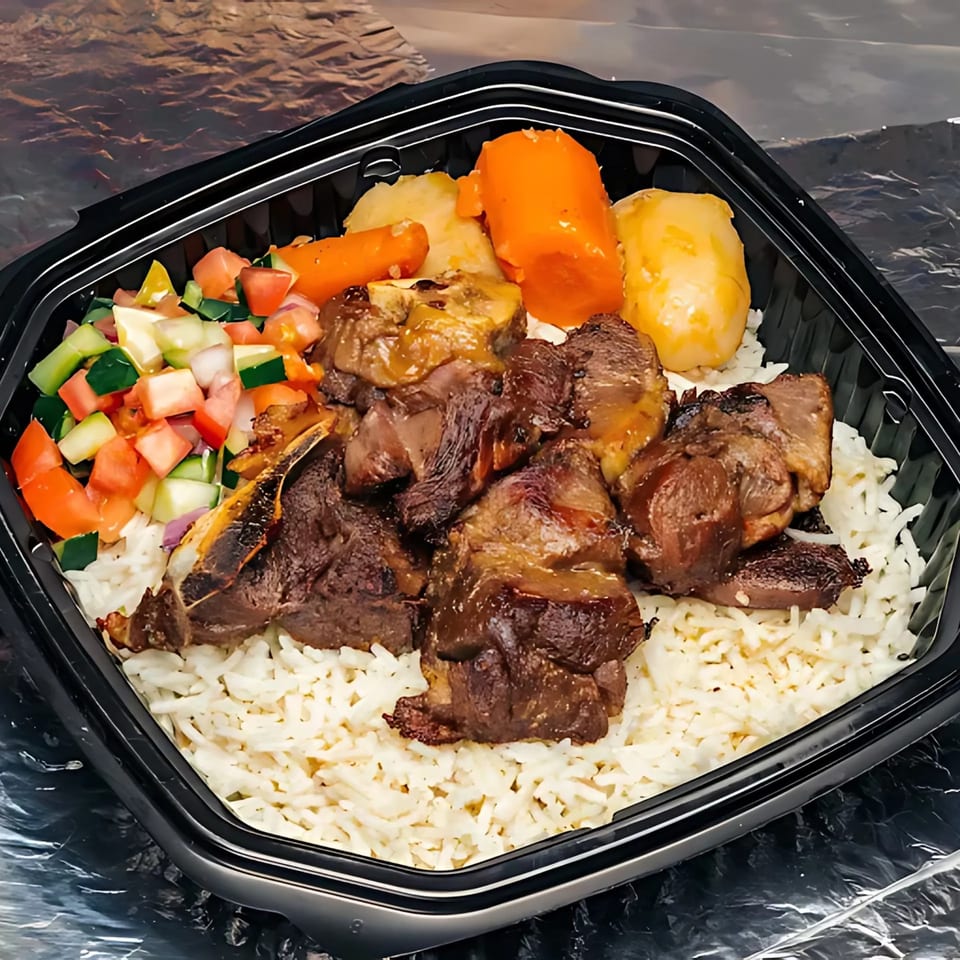 Mediterranean lamb and rice dish with carrots, potatoes, and a side salad in a black container.
